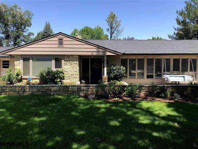 A picture representing learning about Champion Realty's services. A mid century modern home with front porch swing.